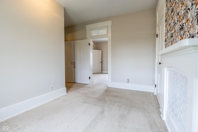 empty room featuring baseboards and carpet flooring