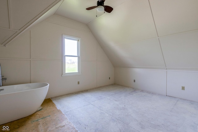 interior space featuring a soaking tub, a ceiling fan, and vaulted ceiling