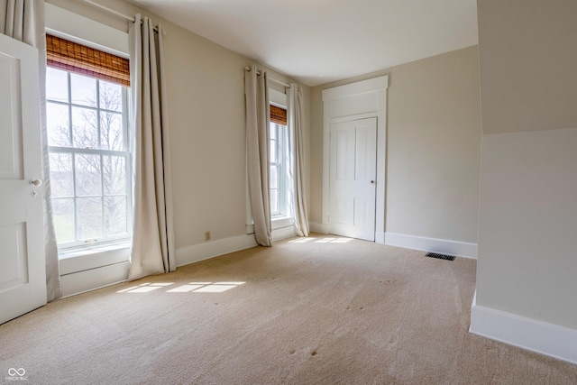 unfurnished room with carpet floors, baseboards, and visible vents
