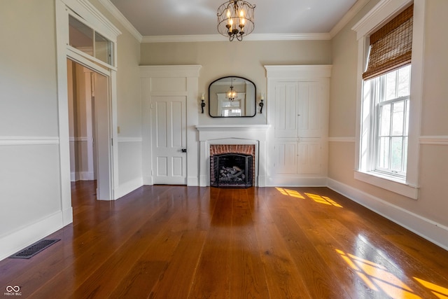 unfurnished living room with a fireplace, visible vents, an inviting chandelier, and wood finished floors