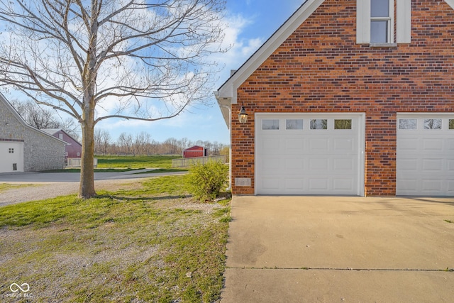 view of property exterior featuring driveway, a garage, and brick siding