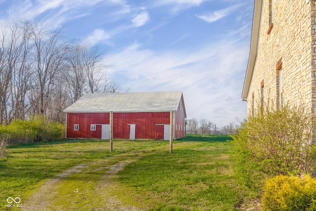 view of pole building featuring driveway and a lawn