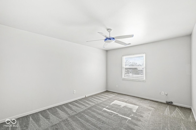 carpeted empty room featuring ceiling fan and baseboards