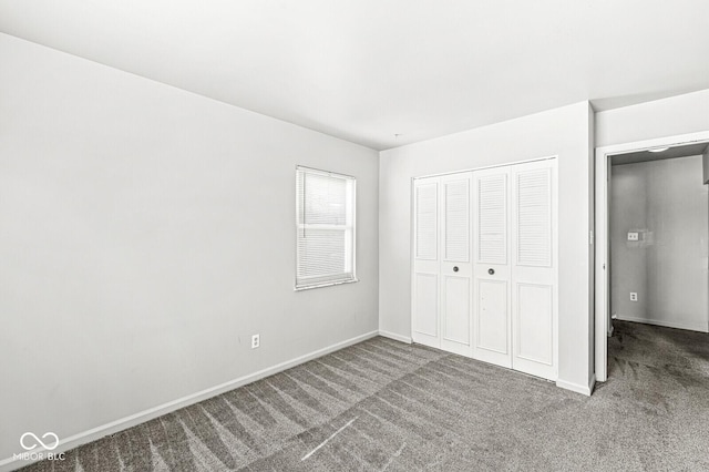 unfurnished bedroom with carpet, a closet, and baseboards