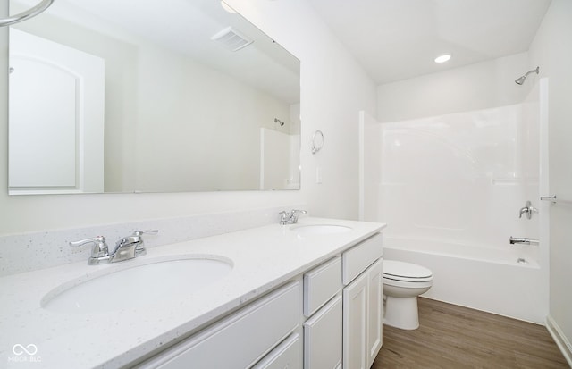 full bathroom featuring hardwood / wood-style flooring,  shower combination, toilet, and vanity