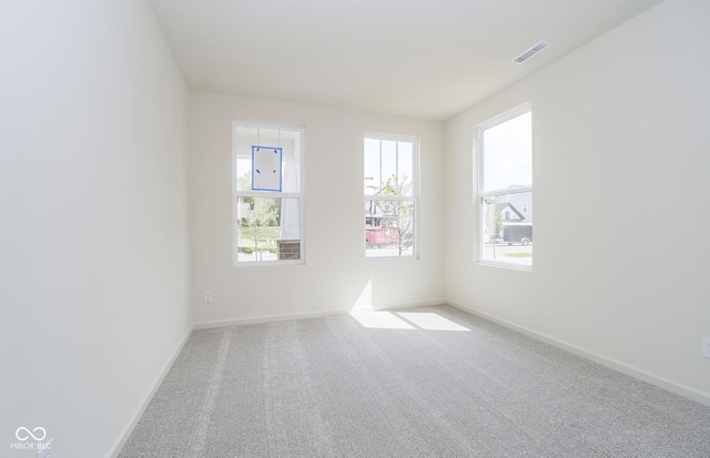 unfurnished room featuring light carpet