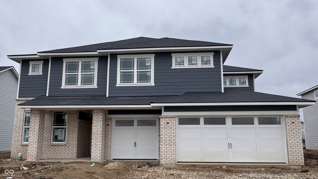 view of front of home with a garage and brick siding
