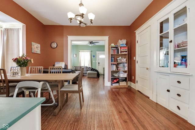 dining space featuring light wood finished floors and an inviting chandelier