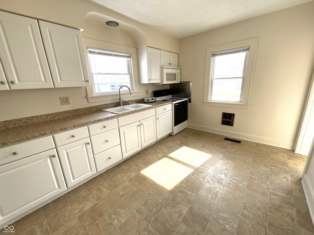 kitchen featuring white appliances, sink, and white cabinets