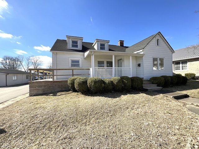 view of front facade with roof with shingles and covered porch