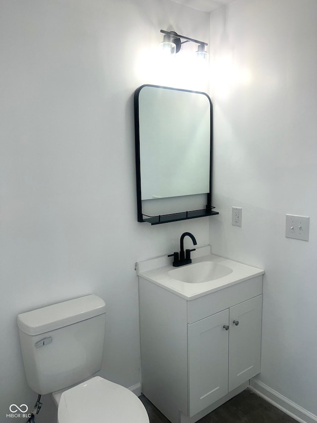 bathroom with vanity, toilet, and baseboards