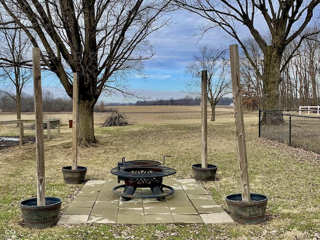 view of yard featuring a rural view, a patio, and a fire pit