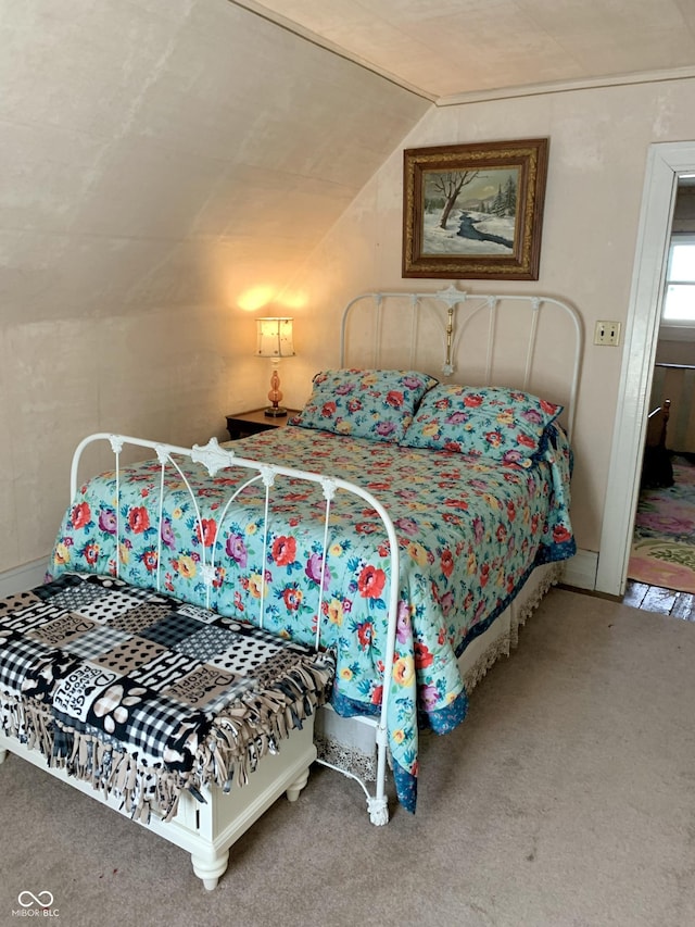 bedroom with carpet floors and vaulted ceiling