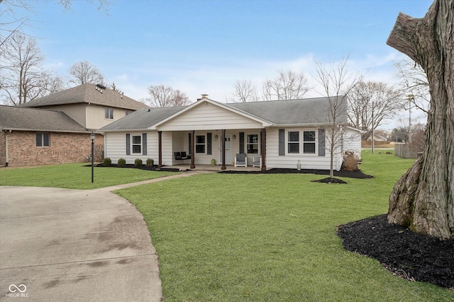 view of front of home featuring covered porch, a shingled roof, and a front yard