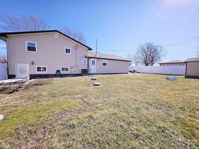 back of house with a yard, central AC unit, and fence