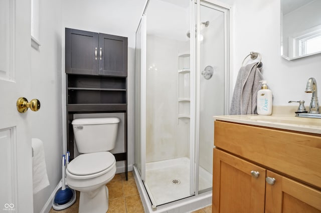 bathroom with toilet, a shower stall, tile patterned flooring, and vanity