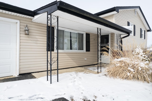 view of snow covered exterior with an attached garage