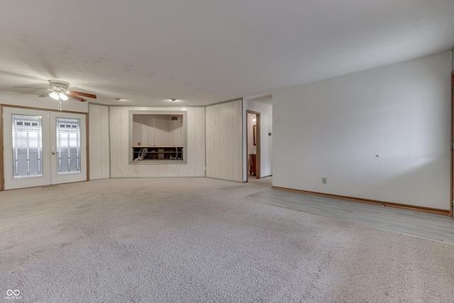 unfurnished living room featuring french doors, light carpet, and ceiling fan