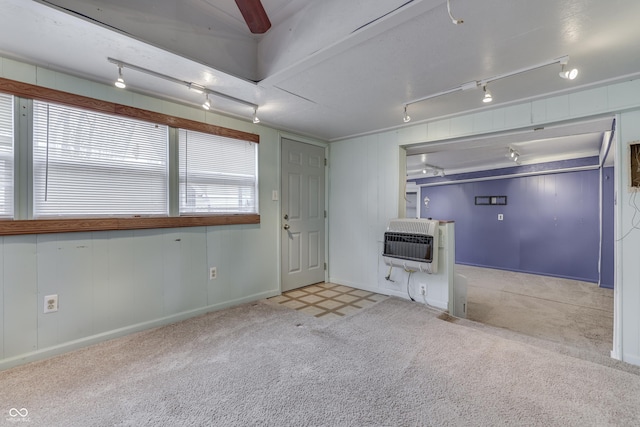 empty room featuring heating unit, light colored carpet, and track lighting