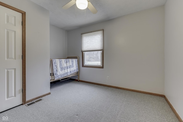 unfurnished bedroom featuring ceiling fan, carpet, and a textured ceiling