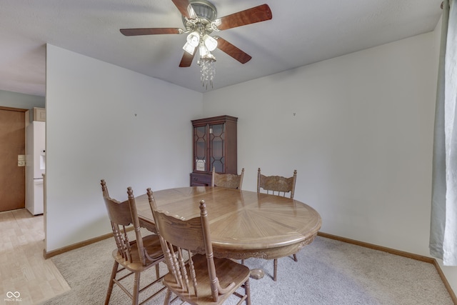 carpeted dining room featuring ceiling fan