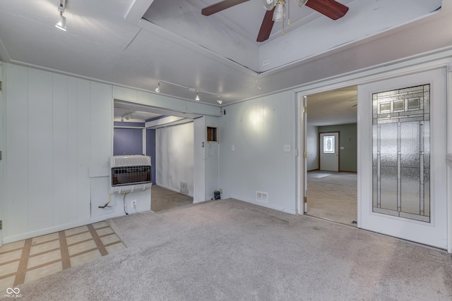 unfurnished living room with rail lighting, ceiling fan, and heating unit