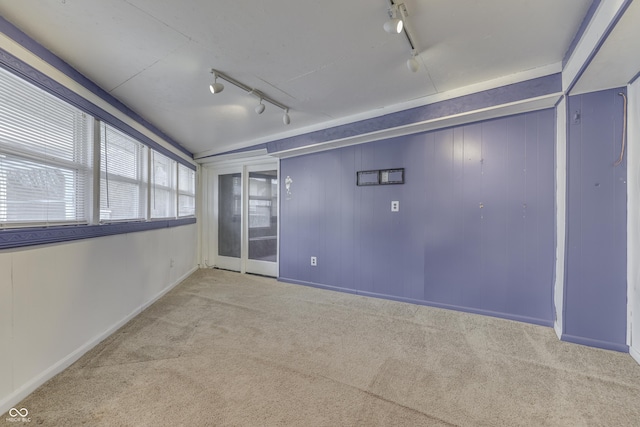 unfurnished room featuring light carpet and track lighting