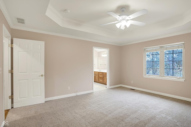 unfurnished bedroom with baseboards, a raised ceiling, visible vents, and light colored carpet