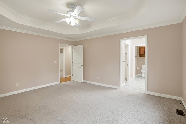 unfurnished bedroom featuring light colored carpet, a raised ceiling, and visible vents