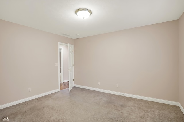 spare room with light carpet and baseboards