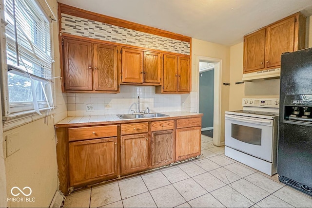 kitchen featuring tasteful backsplash, black fridge with ice dispenser, white electric range, under cabinet range hood, and a sink