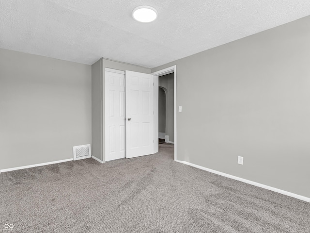 unfurnished bedroom featuring a closet, carpet flooring, and a textured ceiling