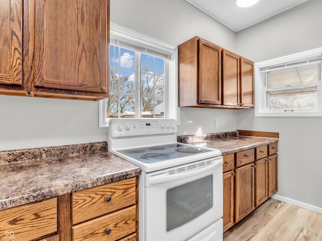 kitchen with light hardwood / wood-style floors and white range with electric stovetop