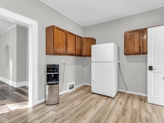 kitchen with light wood-type flooring and white refrigerator