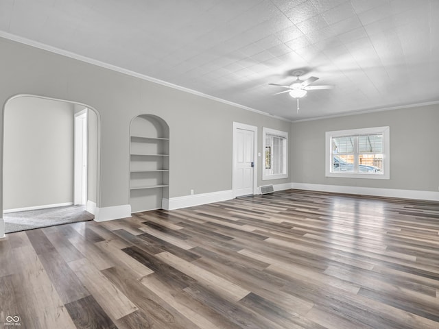 unfurnished living room with hardwood / wood-style floors, ceiling fan, built in shelves, and ornamental molding