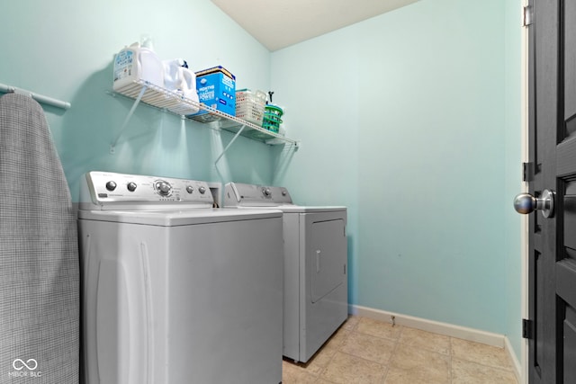 clothes washing area with laundry area, baseboards, and separate washer and dryer