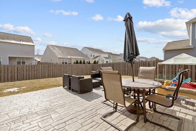 view of patio / terrace with a residential view, outdoor dining area, and a fenced backyard