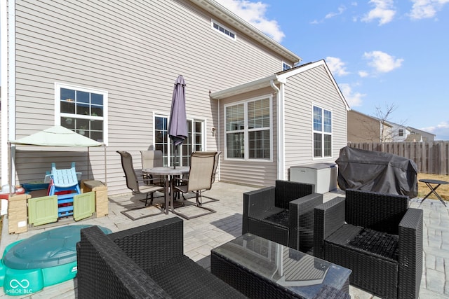 wooden terrace featuring outdoor dining space, an outdoor living space, fence, a grill, and a patio area