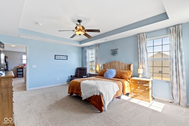 bedroom with a tray ceiling, baseboards, carpet floors, and ceiling fan