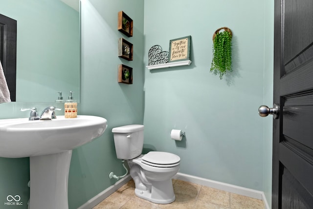 half bathroom with baseboards and toilet