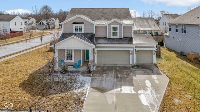 traditional home featuring a residential view, a front yard, roof with shingles, a garage, and driveway