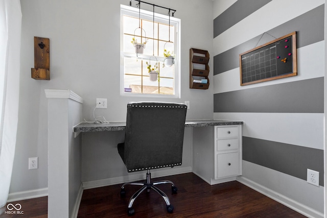 office area featuring built in desk, dark wood-type flooring, and baseboards