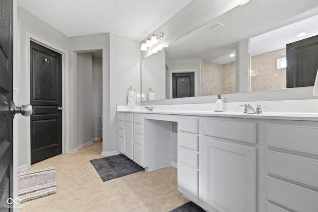 full bath featuring a sink, baseboards, visible vents, and double vanity