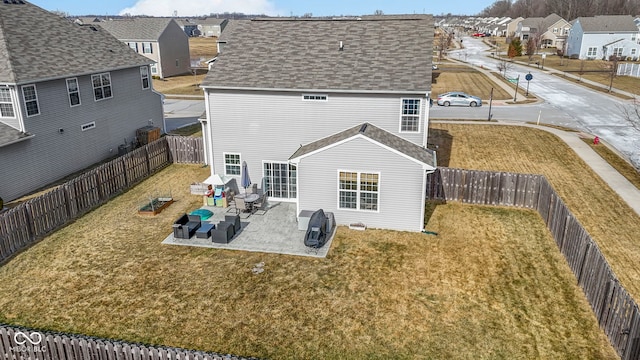 back of property featuring a residential view, a lawn, a fenced backyard, and a patio area