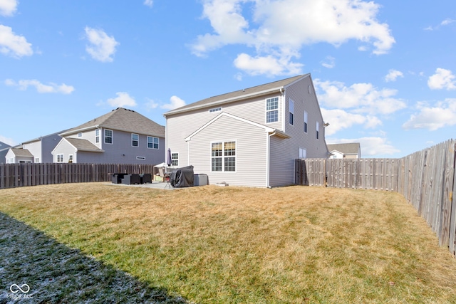 rear view of house featuring a patio, a lawn, and a fenced backyard