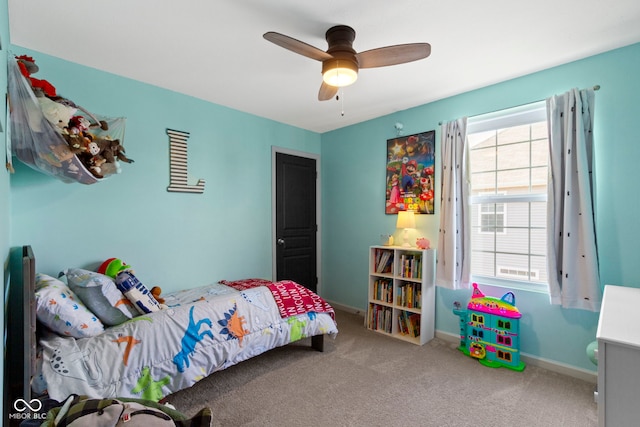 carpeted bedroom featuring baseboards, multiple windows, and a ceiling fan