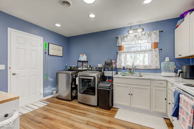 kitchen with white cabinetry, light hardwood / wood-style flooring, sink, electric stove, and washer and dryer