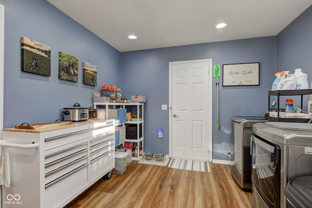 laundry area with light wood-type flooring and separate washer and dryer