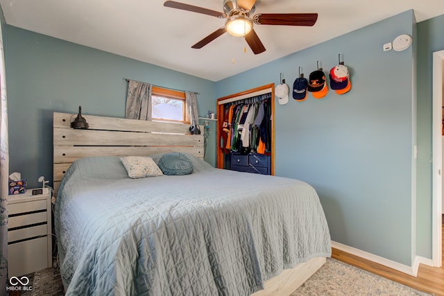 bedroom featuring hardwood / wood-style flooring, ceiling fan, and a closet