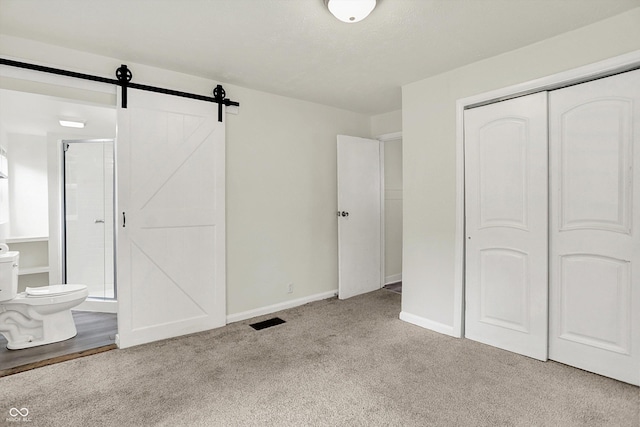 952 N Concord St, Indianapolis, IN 46222 - unfurnished bedroom with carpet floors, connected bathroom, a barn door, and a closet